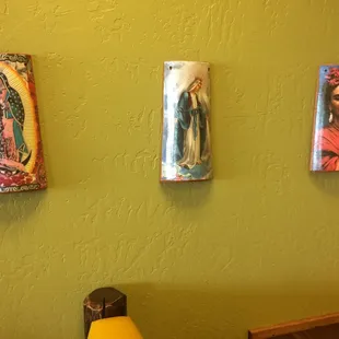 three paintings on a green wall