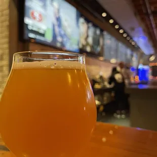 a glass of beer on a bar