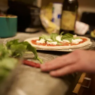 a person preparing a pizza in a kitchen