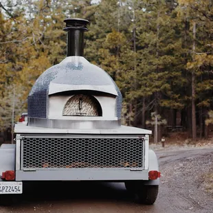 the back end of a truck with a wood fired oven