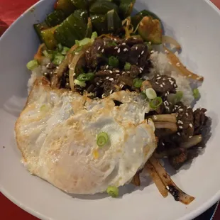 Bulgogi steak with eggs over rice and cucumber kimchi