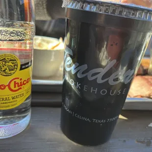 a closeup of a drink and a hot dog