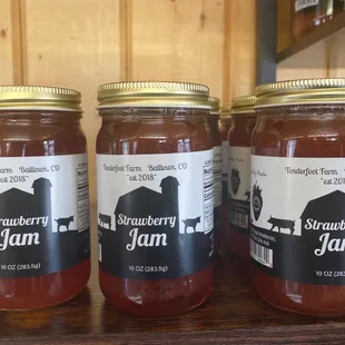 three jars of strawberry jam on a table