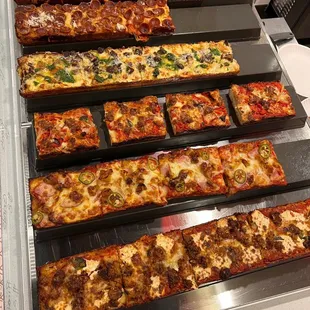 a display of different types of pizzas