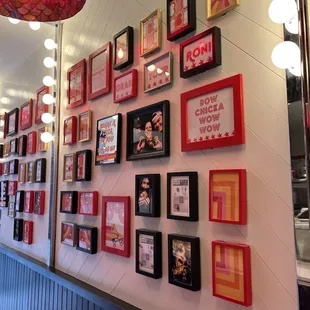 a wall full of framed pictures