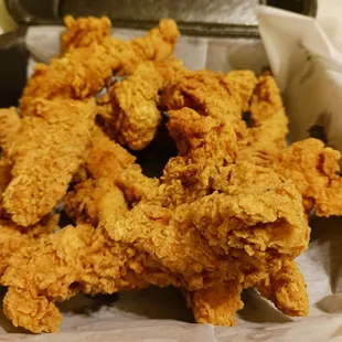 a pile of fried chicken in a basket
