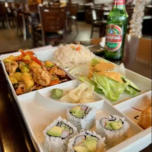 a tray of sushi and a bottle of beer