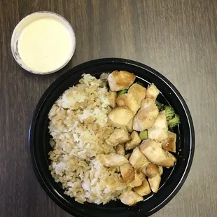 Express chicken bowl with a side of white sauce.