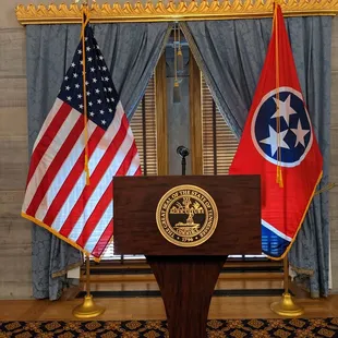 State seal on the podium, with flags (USA and Tennessee) in the back