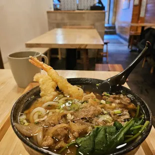 a bowl of soup with shrimp and vegetables
