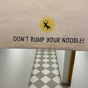 a sign on the wall of a bathroom