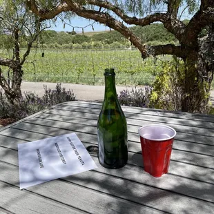 a bottle of wine and a cup on a table