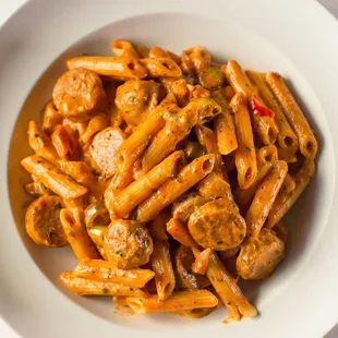 a plate of penne with meat and sauce