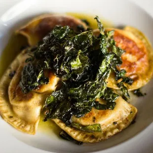 a plate of ravioli with spinach