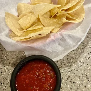 a bowl of chips and a bowl of salsa