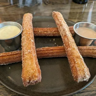 a plate of churros with dipping sauce