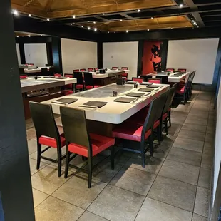 a restaurant with a long table and red chairs
