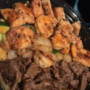 Delicious moonlight combo with steak, shrimp and chicken on top of a bed of rice and veggies. Don't forget the side sauces too!
