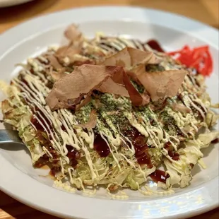 Okonomiyaki - Japanese pancake made with wheat flour, egg, cabbage, and topped w/ regular mayonnaise, seaweed powder, and bonito flakes