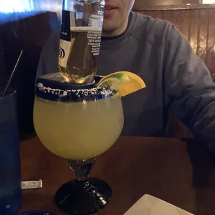 a man sitting at a table with a margarita