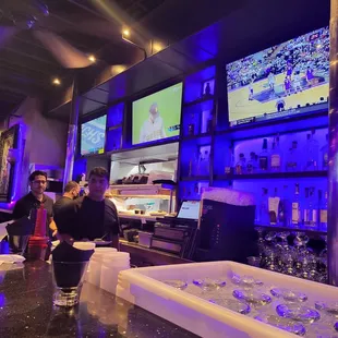 a bar with people watching televisions