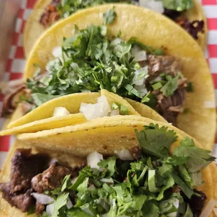 three tacos on a checkered tray