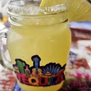 a margarita in a jar with a slice of lime