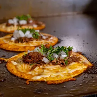 three flatbreads with pulled pork and onions