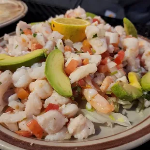 a plate of shrimp and rice with avocado