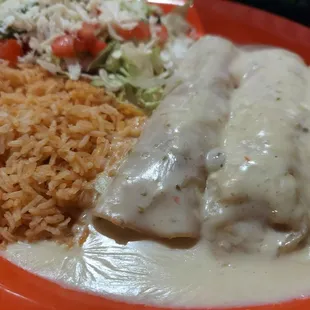 a plate of mexican food with rice and a salad