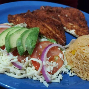 a plate of food with rice, avocado, tomatoes, and meat