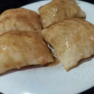 four empanadas on a white plate
