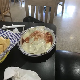 a plate of nachos and a bowl of chips