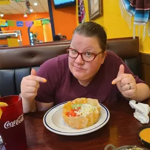 a woman sitting at a table with a plate of food