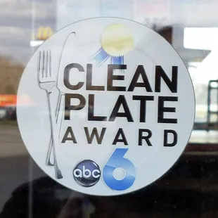 a clean plate award sign in a window