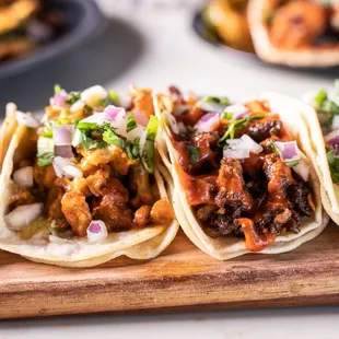 a variety of tacos on a cutting board