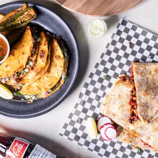a plate of quesadillas and a bottle of beer