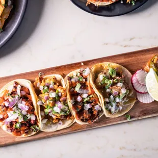 a variety of tacos on a cutting board