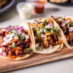three tacos on a cutting board
