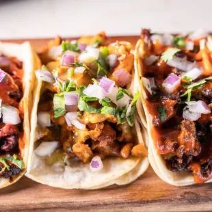 three tacos on a cutting board