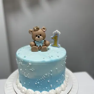 a cake with a teddy bear on top