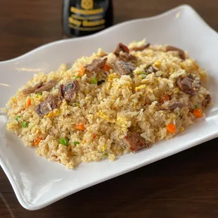 a plate of rice with meat and vegetables