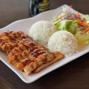 a plate of rice, chicken, and salad