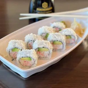 a plate of sushi with chopsticks