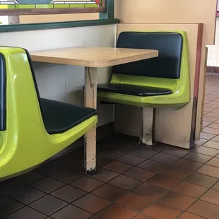 a table and two green chairs