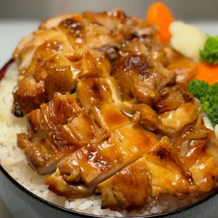 a bowl of rice with chicken and vegetables