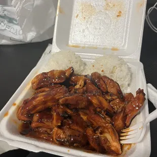 a takeout box of chicken and rice