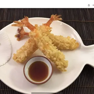 a plate of tempura with dipping sauce