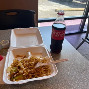 a container of noodles and a bottle of coke