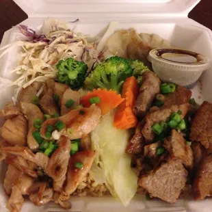 Chicken and Steak plate on a bed of brown rice with sides of steam veggies, cole slaw and two gyozas. $6.95
